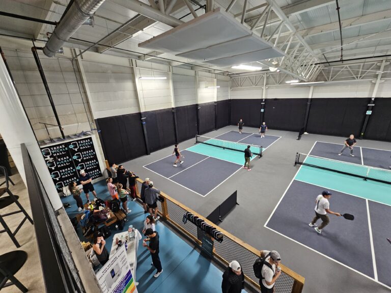 Multiple indoor pickleball courts with games in progress at Texas Pickle Hall in San Antonio